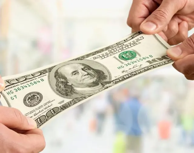 Two hands pulling on a one hundred dollar bill